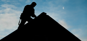 Silhouette of builder on roof